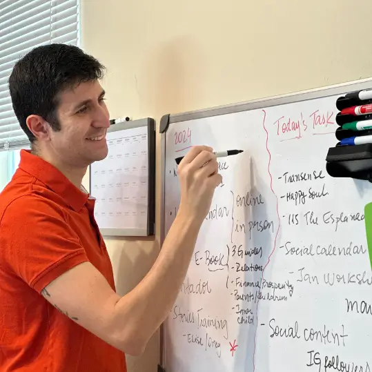 Digital marketing strategist adding tasks to a project timeline on a whiteboard.